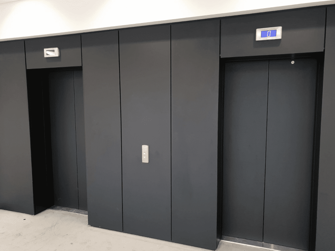 A black elevator with two doors and one door closed.