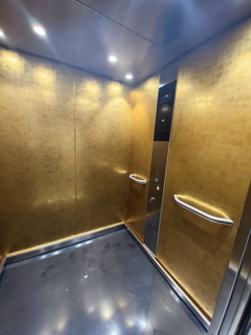 A gold elevator with two doors and one lift