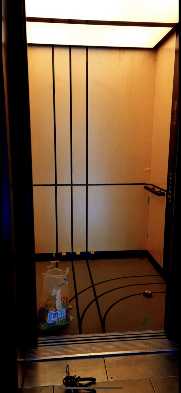 A small elevator with some wires on the side