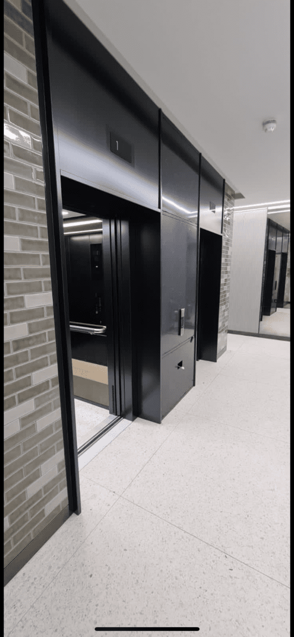 A black door in the hallway of an office building.