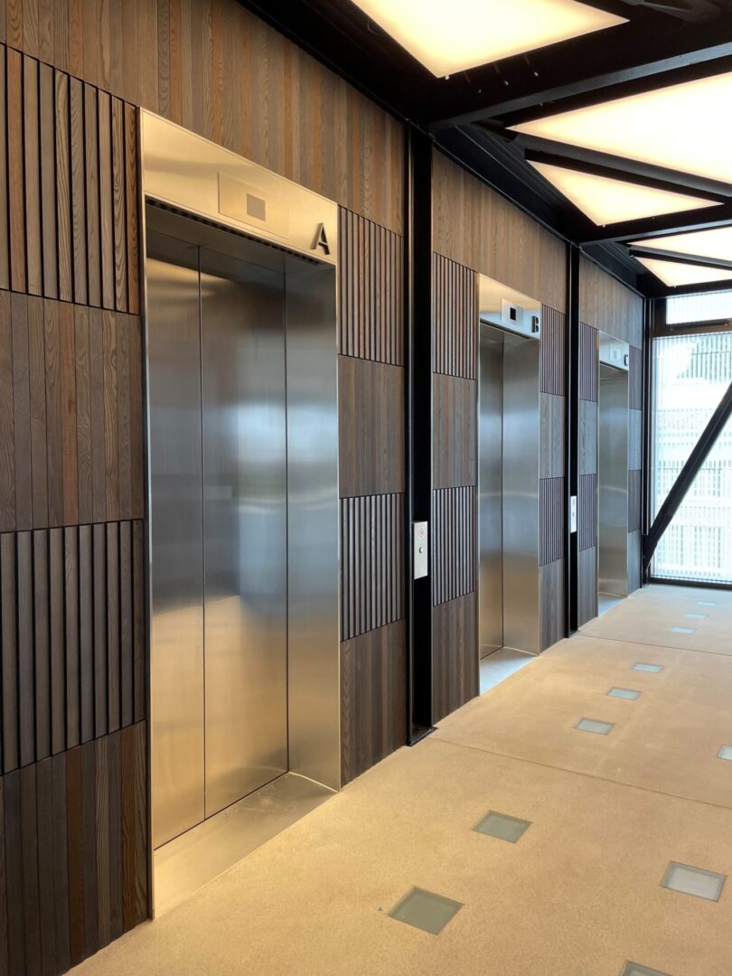 A room with two elevators and some wood panels
