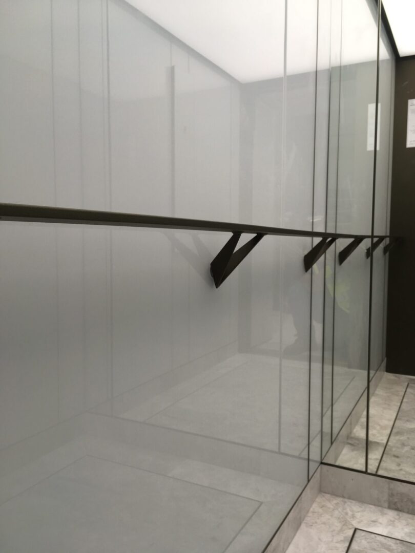 A glass wall with some black handles on it